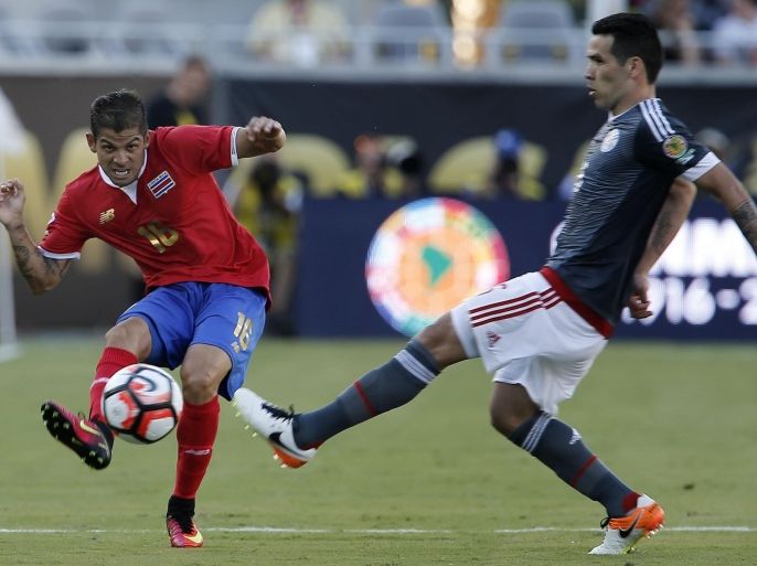 Jun 4, 2016; Orlando, FL, USA; Costa Rica defender Cristian Gamboa (left) kicks ball as Paraguay midfielder Celso Ortiz (16) approaches in the second half during the group play stage of the 2016 Copa America Centenario at Camping World Stadium. Mandatory Credit: Reinhold Matay-USA TODAY Sports