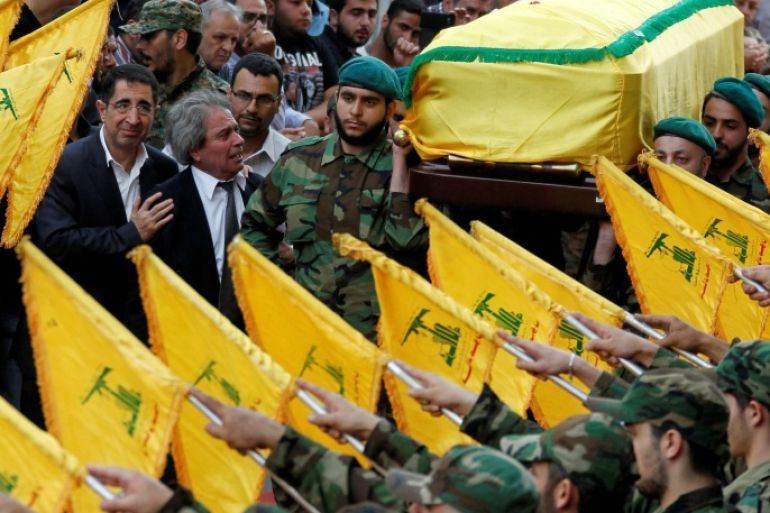 Hezbollah Industry Minister Hussein Hajj Hassan (L) comforts the brother of top Hezbollah commander Mustafa Badreddine, who was killed in an attack in Syria, as Hezbollah members carry his coffin during his funeral in Beirut's southern suburbs, Lebanon, May 13, 2016. REUTERS/Aziz Taher