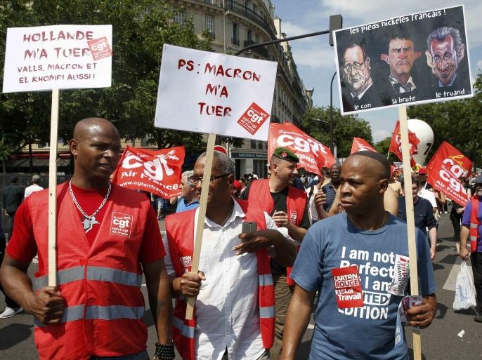 French union employees carry anti-government protest signs during a demonstration against plans to reform French labour laws near the Place de la Bastille square in Paris, France, June 23, 2016. REUTERS/Baz Ratner