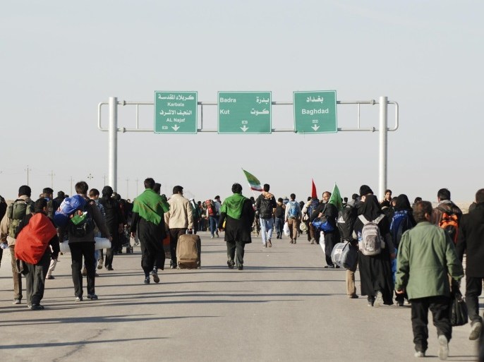 Iranian Shi'ite pilgrims walk on a road after entering Iraq through Wasit province at the Iraq-Iran border crossing, December 8, 2014. An influx of Iranian pilgrims over the past few days is seen at the Iraq-Iran border crossing as they head towards Iraq's holy city of Kerbala to attend the holy Shi'ite ritual of Arbaeen, which falls 40 days after the holy day of Ashura. REUTERS/Jaafer Abed (IRAQ - Tags: RELIGION)