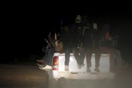 Migrants sit on the back of a truck as it is driven through a dust road at night in the desert town of Agadez, Niger in this May 25, 2015 file photo. To Match Insight EUROPE-MIGRANTS/SAHARA. REUTERS/Akintunde Akinleye/Files