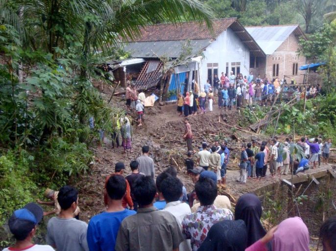 Residents gather in front of a house which was damaged by a landslide in Susukan village, Banjarnegara, Indonesia, 19 June 2016. The death toll in a number of disasters in central Java Region since 18 June is 12 . While areas experiencing severe landslides, amongst others are Banjarnegara, Kebumen and Purworejo.