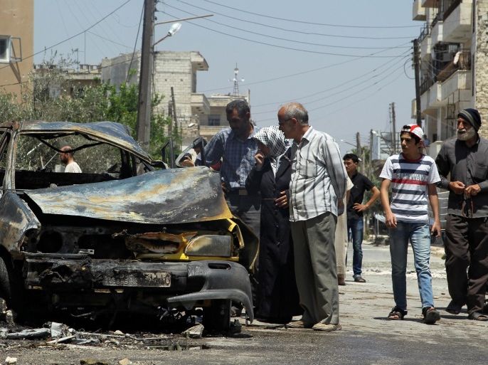 Civilians inspect a burnt car at a site hit by an airstrike in the rebel-controlled city of Idlib, Syria June 29, 2016. REUTERS/Ammar Abdullah