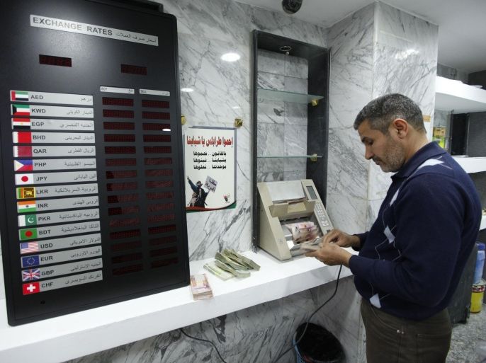 A man uses a currency counting machine to count Libyan dinar at a currency exchange office in central Tripoli March 30, 2014. Libya is burning through central bank reserves and scrapping infrastructure projects to overcome its worst budget crisis in decades after the seizure of oil installations by armed groups has reduced the government's income almost to zero. Picture taken March 30, 2014. REUTERS/Ismail Zitouny (LIBYA - Tags: POLITICS CIVIL UNREST BUSINESS)