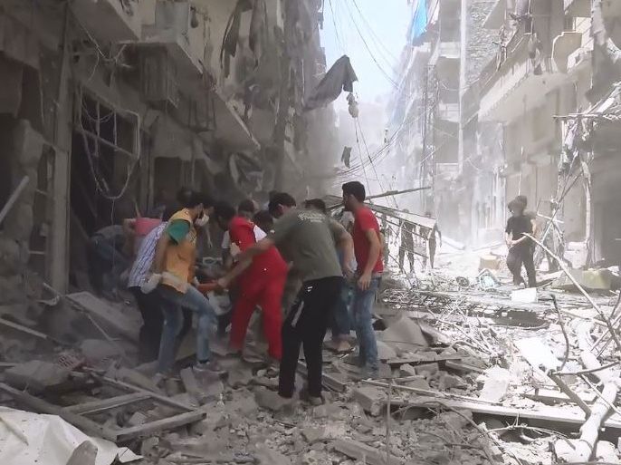 مسعفون يحمل أحد ضحايا الغارات السورية والروسية على حلب