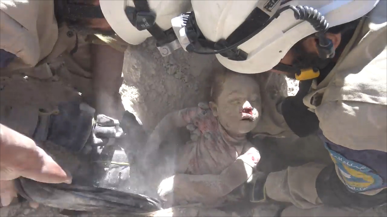 ‪أحد طواقم الدفاع المدني بحلب ينتشل طفلا قضى تحت القصف‬ (ناشطون)