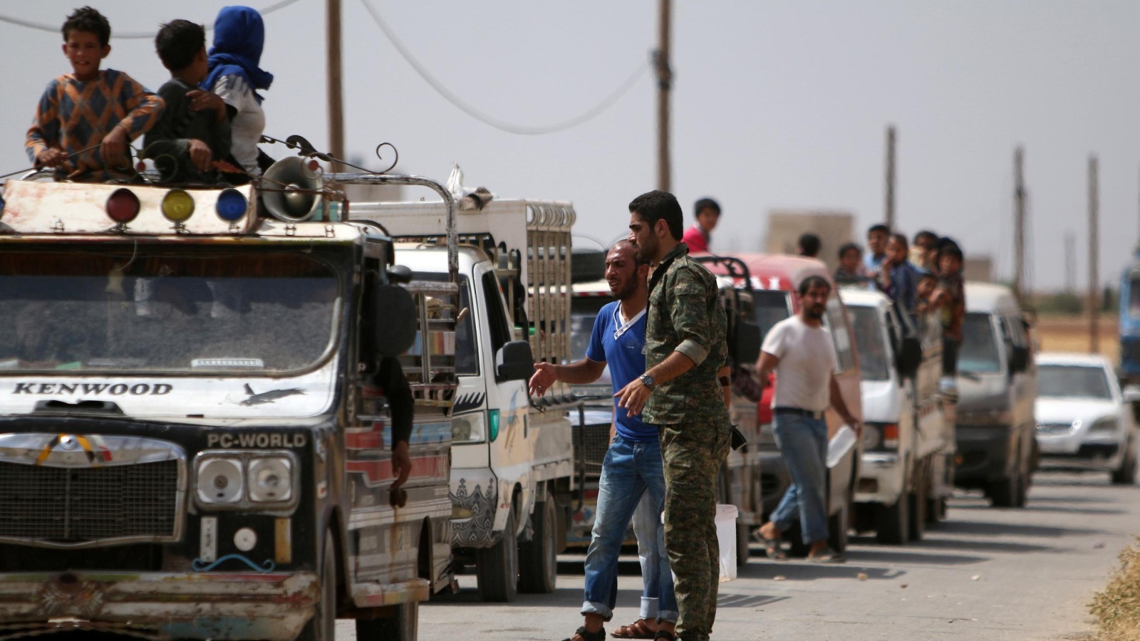 ‪مركبات تقل مدنيين نازحين من منبج هربا من المعارك بين قوات كردية وتنظيم الدولة‬ ( رويترز)