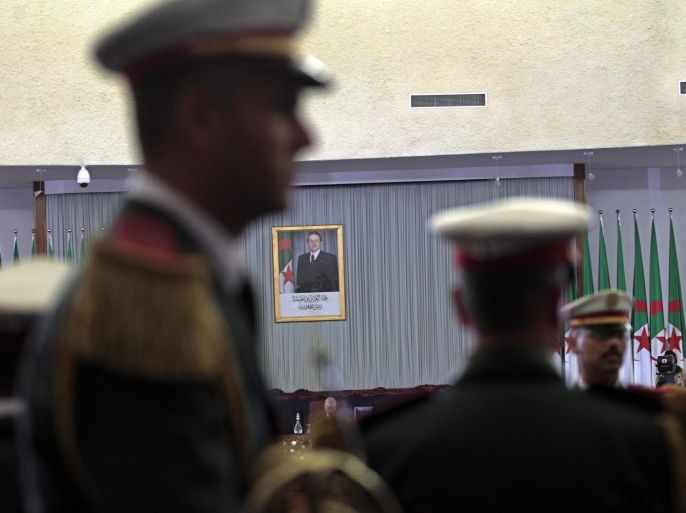 A photograph of Algerian president Abdelaziz Bouteflika is seen as republican guards attend the constitutional reforms vote session in Algiers, Algeria February 7, 2016. Algerian lawmakers approved constitutional reforms on Sunday proposed by President Abdelziz Bouteflika, including reinstating a two-term limit for the presidency and expanding parliament's powers. REUTERS/Ramzi Boudina