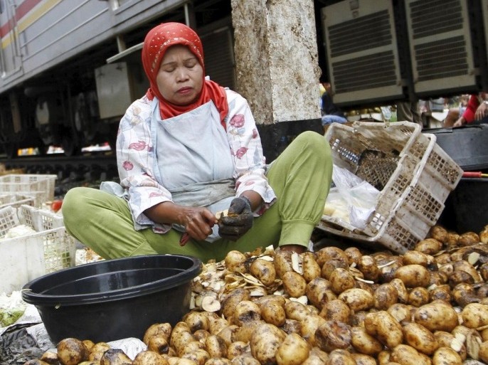 A woman peels potatoes for sale at a market located along a railway line in West Jakarta, Indonesia March 1, 2016. Indonesia's annual inflation rate increased slightly more than expected in February, the statistics bureau said on Tuesday. REUTERS/Garry Lotulung