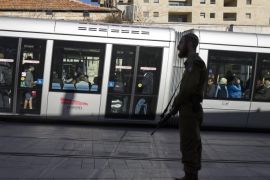 A religious Israeli solder armed with an assault rifle stands guard on a platform of the Light Rail trolley on a central Jerusalem pedestrian street, Israel, 17 January 2016. Many armed civilians and soldiers are seen in Jerusalem, in addition to the still-increased number of police and Border Police, due to the recent and ongoing number of stabbing attacks by Palestinians.