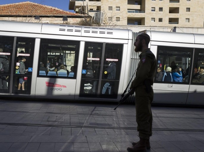 A religious Israeli solder armed with an assault rifle stands guard on a platform of the Light Rail trolley on a central Jerusalem pedestrian street, Israel, 17 January 2016. Many armed civilians and soldiers are seen in Jerusalem, in addition to the still-increased number of police and Border Police, due to the recent and ongoing number of stabbing attacks by Palestinians.