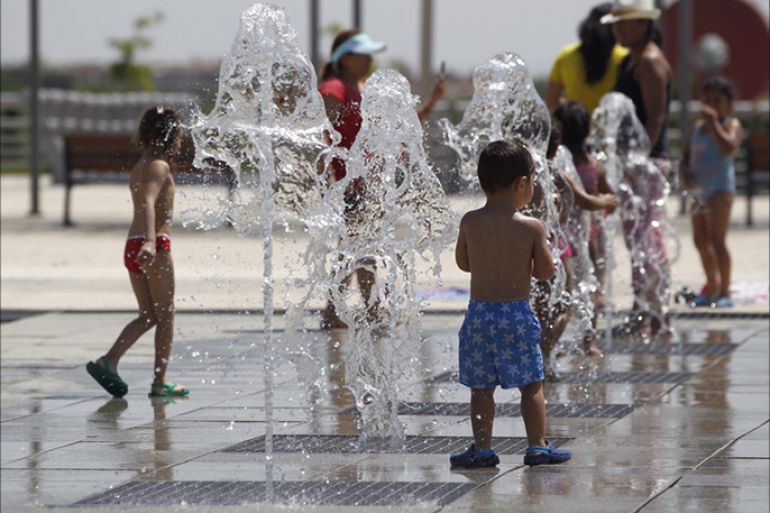 epa05405272 Children play in a fountain in a park in Madrid, Spain, 03 July 2016. Authorities issued a yellow alert for hot weather in Madrid as temperatures could reach 38 Celsius degrees. EPA/JAVIER LIZON