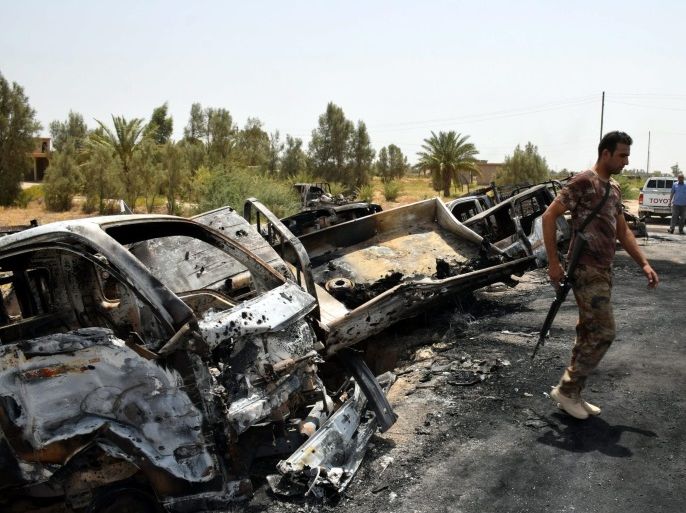 A picture made available on 30 June 2016 shows an Iraqi soldier inspecting burnt trucks which was used by Islamic state militants after a heavy clashes with Iraqi forces near Amiriyat al-Fallujah town, southwest of of Fallujah city, western Iraq, 29 June 2016. The Iraqi forces destroyed a convoy of Islamic state group and killed at least 15 islamic state militants while they were trying to flee from Fallujah to desert, security officials said. EPA/NAWRAS AAMER ATTENTIO