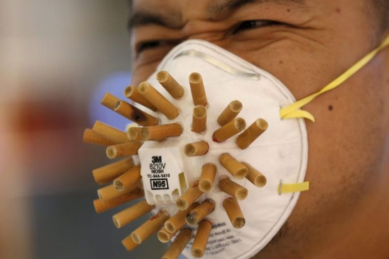 A man wears a mask decorated with cigarette butts, designed by Chinese designer Wen Fang at Wen's "Maskbook" workshop during the Beijing Design Week 2015 in Beijing, China, October 2, 2015. In the workshop, participants decorated and designed masks with their own ideas, as a symbol of collective citizen action for climate change, and against pollution and smoking in public place, the designer said. REUTERS/Kim Kyung-Hoon TPX IMAGES OF THE DAY