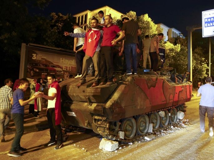 Supporters of Turkish President Tayyip Erdogan stand on an abandoned tank during a demonstration outside parliament building in Ankara, Turkey, July 16, 2016. REUTERS/Osman Orsal