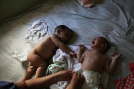 Five-month-old twins Laura (R) and Lucas lie on a bed at their house in Santos, Sao Paulo state, Brazil April 20, 2016. Among the mysteries facing doctors in Brazil battling an epidemic of the little-known Zika virus are cases of women giving birth to twins with only one suffering from microcephaly, a birth defect associated with the disease. Jaqueline Jessica Silva de Oliveira hoped doctors were wrong when a routine ultrasound showed that one of her unborn twins would