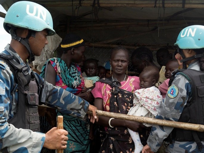 United Nations peacekeepers control South Sudanese women and children before the distribution of emergency food supplies at the United Nations protection of civilians (POC) site 3 hosting about 30,000 people displaced during the recent fighting in Juba, South Sudan, July 25, 2016. REUTERS/Adriane Ohanesian