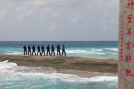 Soldiers of China's People's Liberation Army (PLA) Navy patrol near a sign in the Spratly Islands, known in China as the Nansha Islands, February 9, 2016. The sign reads "Nansha is our national land, sacred and inviolable." REUTERS/Stringer/File Photo ATTENTION EDITORS - THIS PICTURE WAS PROVIDED BY A THIRD PARTY. THIS PICTURE IS DISTRIBUTED EXACTLY AS RECEIVED BY REUTERS, AS A SERVICE TO CLIENTS. CHINA OUT. NO COMMERCIAL OR EDITORIAL SALES IN CHINA. FROM THE FILES P