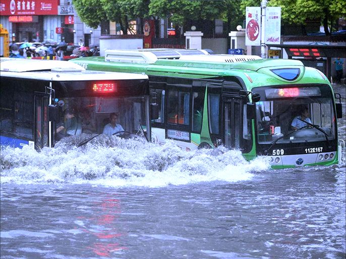 حافلتان تحاولان شق طريقهما وسط الفيضانات التي اجتاحت شوارع المدينة في ووهان