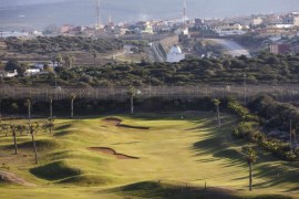 The Moroccan city of Nador and mount Gurugu are seen in the background, as people play on a golf course in Spain's north African enclave Melilla, December 8, 2013. Melilla is a small Spanish enclave on Morocco's Mediterranean coast. Armed guards and razor wire lining the 12-km (7.5-mile) frontier around the town have long discouraged Africans fleeing poverty and conflict from seeing Melilla as a gateway to Europe, 180 km (110 miles) away across open water. But despera