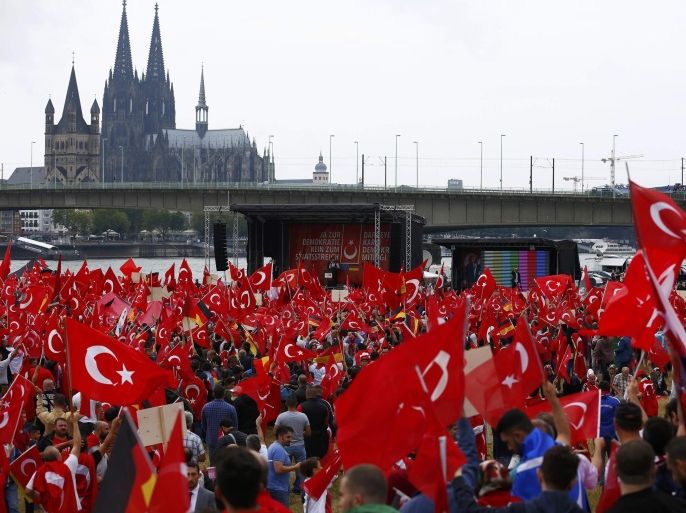 Supporters of Turkish President Tayyip Erdogan wave Turkish flags during a pro-government protest in Cologne, Germany July 31, 2016. REUTERS/Thilo Schmuelgen