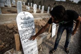 A picture made available on 22 August 2016 showing a man pointing at tombstones in a mass grave of the victims of the chemical attack, Most tombstones indicate that many bodies buried in the same grave, Erbeen, outskirts of Damascus, Syria, 21 August 2016. On 21 August 2013 Ghouta was bombed by Sarin, a chemical agent that affects the nervous system and prohibited by the Chemical Weapons Convention (CWC) as a weapon of mass destruction. The number of casualties is unknown with most reports indicating an average of 1400 death. The bombing was condemed by the Arab League, the European Union, and the United States, with a UN investigation team reporting that the nature, quality, and quantity of agents used in the attack idicate that the perpetrators had access to the chemical weapons stockpile of the Syrian military, and the expertise to arm them. The Syrian government accepted a US-Russia negotiated deal to turn over its chemical weapons stockpiles for destruction, and declated its intention to join the CWC. EPA/MOHAMMED BADRA ATTENTION EDITORS: PICTURE CONTAINS GRAPHIC CONTENT