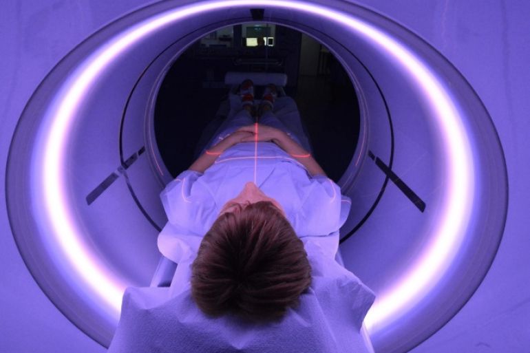 An x-ray assistant lies in a CT scanner for purposes of demonstration in the emergency room of the University Hospital (UKJ) in Jena, Germany, 20 January 2016. The UKJ is the first hospital in Germany to employ a new kind of CT scanner in the emergency room. Various steps of treatment can be performed through with a single scan, while simultaneously reducing radiation exposure for the patient. The GE Healthcare scanner is called the 'Revolution CT.' 
