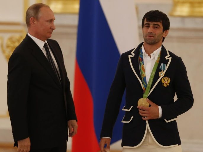 Russian President Vladimir Putin (L) and Russia's Olympic gold medal winner in men's 60kg judo event Beslan Mudranov (R) attends a presentation ceremony for Russian Rio-2016 Olympic medal winners in the Kremlin in Moscow, Russia, 25 August 2016.