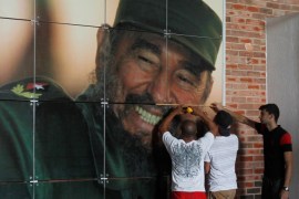 Workers install a photograph of Cuba's former president Fidel Castro at the Expocuba exhibition center in preparation for his upcoming 90th birthday in Havana, Cuba, August 12, 2016. REUTERS/Stringer EDITORIAL USE ONLY. NO RESALES. NO ARCHIVE.