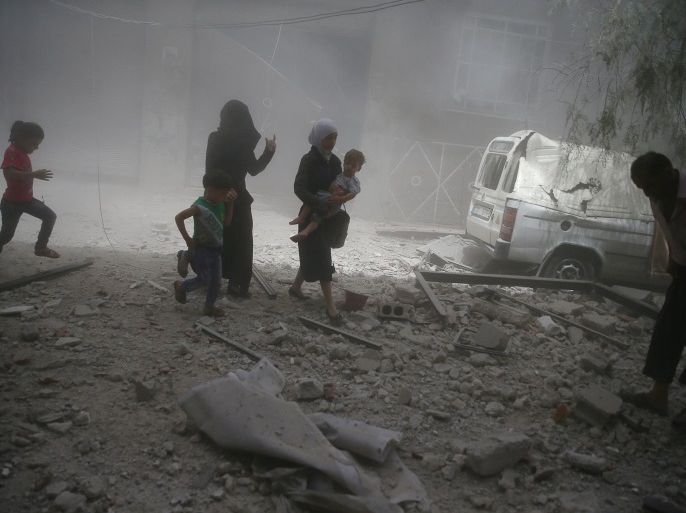 Residents flee a site after an air strike on the rebel-held besieged town of Douma, eastern Damascus suburb of Ghouta, Syria August 20, 2016. REUTERS/Bassam Khabieh