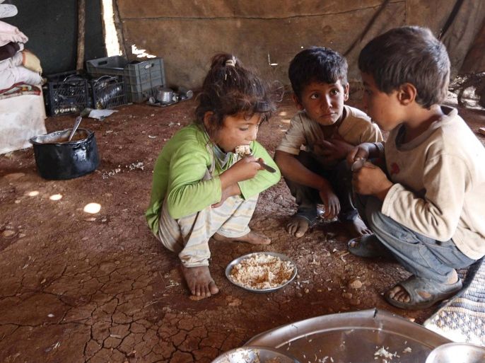 Internally displaced children, who along with their family fled the violence in Aleppo's Handarat area, eat inside a tent in the northern countryside of Aleppo October 8, 2014. REUTERS/Jalal Al-Mamo (SYRIA - Tags: POLITICS CIVIL UNREST SOCIETY POVERTY TPX IMAGES OF THE DAY)