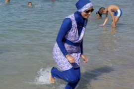 A woman wearing a burkini walks in the water August 27, 2016 on a beach in Marseille, France, the day after the country's highest administrative court suspended a ban on full-body burkini swimsuits that has outraged Muslims and opened divisions within the government, pending a definitive ruling. REUTERS/Stringer