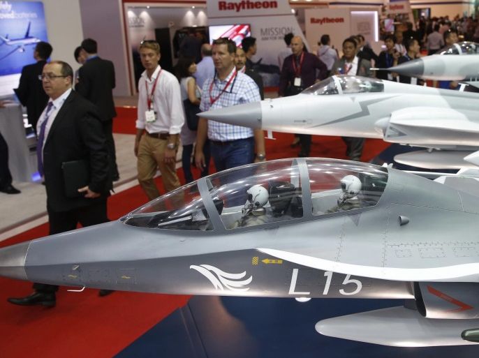 Visitors pass models of fighter jets manufactured by China National Aero Technology Import and Export Corporation (CATIC) during the Singapore Airshow at Changi Exhibition Center February 17, 2016. REUTERS/Edgar Su