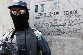 شرطي أفغاني يحرس مدرسة محلية ترعاها "وكالة التعاون الدولي اليابانية" في مدينة قندهار يوم 11 مايو/أيار 2010.