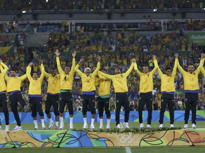 2016 Rio Olympics - Soccer - Victory Ceremony - Men's Football Tournament Victory Ceremony - Maracana - Rio de Janeiro, Brazil - 20/08/2016. Players (BRA) of Brazil jump on the podium after they won gold medals for defeating Germany. REUTERS/Bruno Kelly FOR EDITORIAL USE ONLY. NOT FOR SALE FOR MARKETING OR ADVERTISING CAMPAIGNS.