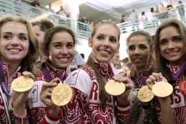 Members of the Russian rhythmic gymnastics team pose with their gold medals after returning from the 2012 London Olympics at Moscow's Sheremetyevo airport August 13, 2012. Russia's Olympic team brought home 24 gold, 26 silver and 32 bronze medals from the London games. REUTERS/Maxim Shemetov (RUSSIA - Tags: SPORT GYMNASTICS OLYMPICS)