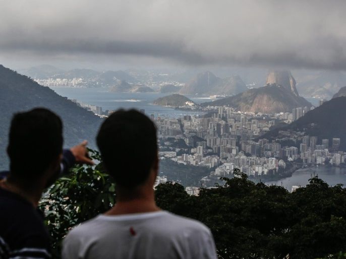 People look down at a view of the Rio de Janeiro downtown area from a hill in Rio de Janeiro, Brazil, 30 July 2016. The Olympics start on 05 August.