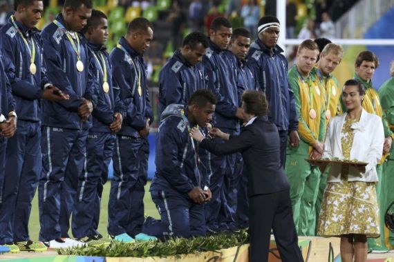 2016 Rio Olympics - Rugby - Men's Victory Ceremony - Deodoro Stadium - Rio de Janeiro, Brazil - 11/08/2016. Britain's Princess Anne awards a gold medal to a member of team Fiji on his knees during the victory ceremony. REUTERS/Alessandro Bianchi (BRAZIL - Tags: SPORT OLYMPICS SPORT RUGBY ROYALS) FOR EDITORIAL USE ONLY. NOT FOR SALE FOR MARKETING OR ADVERTISING CAMPAIGNS.