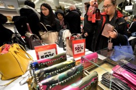 Women bargain hunters inspect handbags reduced in price for the Boxing Day sales at Selfridges department store, Oxford Street, central London, United Kingdom, 26 December 2015. Shoppers flocked to the city centre as stores slash prices in the traditional Boxing Day sales.
