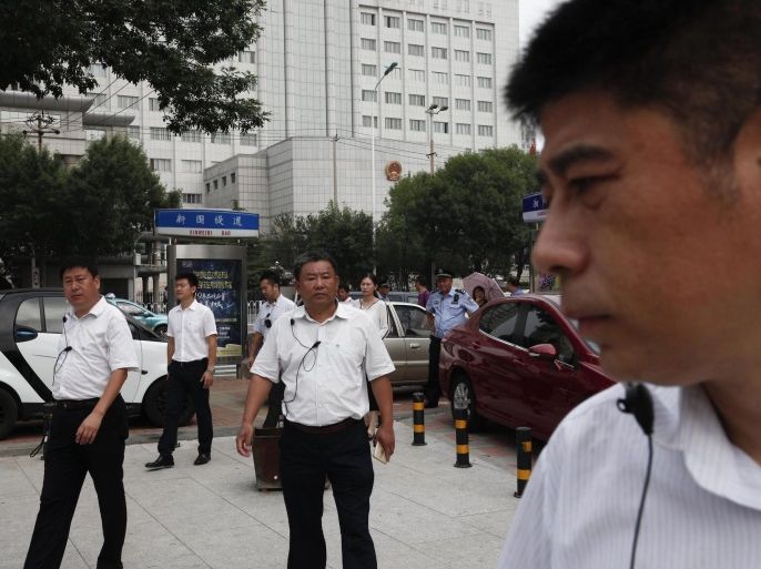 Chinese men in plain clothes, believed to be security personnel, follow journalists in an apparent attempt to affect photo and video coverage outside The No.2 Intermediate People's Court in Tianjin City, located northeast of Beijing, China, 04 August 2016. A Chinese trial court in Tianjin on 04 August sentenced Chinese human rights lawyer Zhou Shifeng to seven years imprisonment for subversion. According to media reports, the prosecution accused Shifeng of encouraging