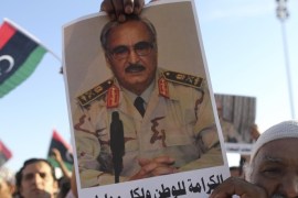 A man holds a picture of General Khalifa Haftar during a demonstration in support of "Operation Dignity" in Benghazi in this May 23, 2014 file photo. Growing frustration over the reality of life in eastern Libya, which contrasts with the promises of politicians, is feeding support for Haftar, who has set himself up as a warrior against Islamist militancy and who some also see as their saviour. REUTERS/Esam Al-Fetori/Files (LIBYA - Tags: POLITICS CIVIL UNREST)