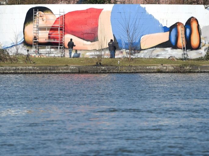 The photo of the dead Syrian boy Aylan Kurdi served as a template for a graffiti that artists Justus Becker and Oguz Sen sprayed at the harbour in Frankfurt (Main), Germany, 09 March 2016. 'Europe dead - Death and the money' is the title of the critical project near the European Central Bank. The artwork is said to be done by 10 March.
