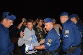 أفراد الشرطة المجرية يفتشون لاجئين عربا بمدينة روسكي على الحدود مع صربيا