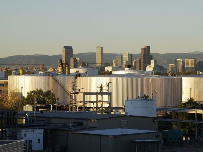 Oil storage tanks are seen at sunrise with the Rocky Mountains and the Denver downtown skyline in the background October 14, 2014. Brent crude fell almost 3 percent to a fresh low near $86 a barrel on Tuesday, trading at its weakest level since 2010 after the West's energy watchdog cut its estimates for oil demand this year and next. REUTERS/Rick Wilking (UNITED STATES - Tags: BUSINESS ENERGY)