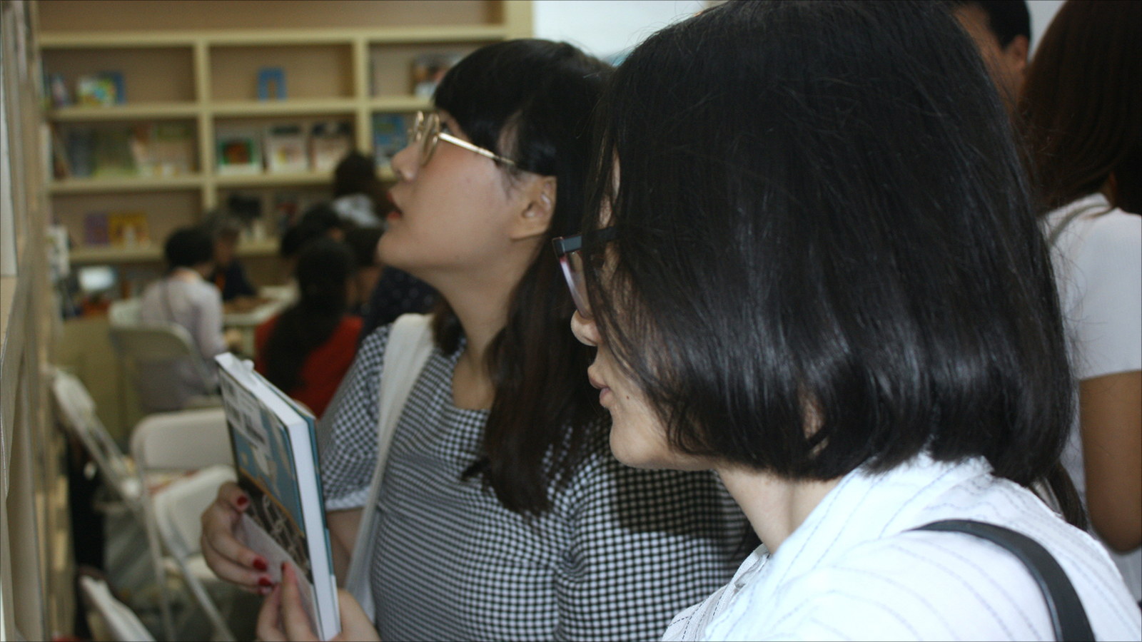 ‪مواطنتان تبحثان عن عناوين كتب مفضلة بمعرض الكتاب‬  (الجزيرة)