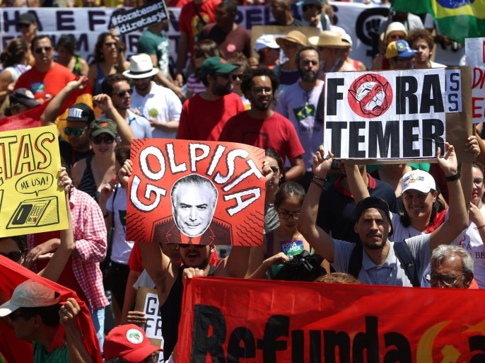 Demonstrators protest against President Michel Temer after the parade celebrating the country's Independence Day in Brasilia, Brazil, September 7, 2016. The signs (L-R) read, "Rights now", "Coup monger", "Out Temer." REUTERS/Adriano Machado