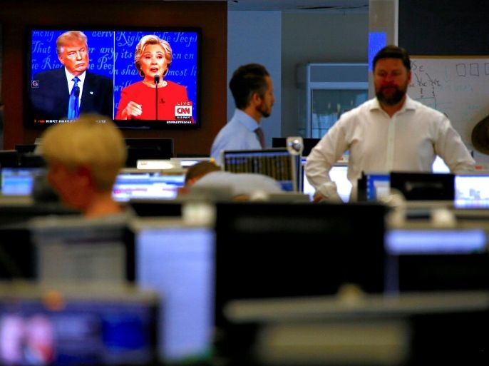 Traders react on the dealing floor of Australia's Westpac Bank in Sydney, Australia, September 27, 2016, as Republican U.S. presidential nominee Donald Trump and Democratic U.S. presidential nominee Hillary Clinton are displayed on screens during the first presidential debate. REUTERS/David Gray