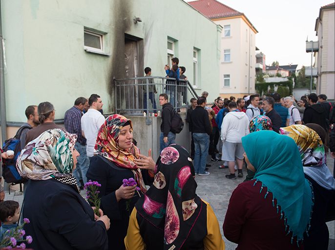 epa05558786 Women stand in front of the Fatih Camii mosque during a silent vigil in Dresden, Germany, 27 September 2016. Two bomb attacks have been committed in front of the mosque and an international congress building in Dresden. EPA/SEBASTIAN KAHNERT