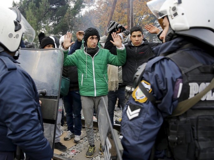 Stranded Moroccan migrants react in front of a Greek police cordon at a border crossing into Macedonia near to the Greek village of Idomeni December 4, 2015. REUTERS/Yannis Behrakis