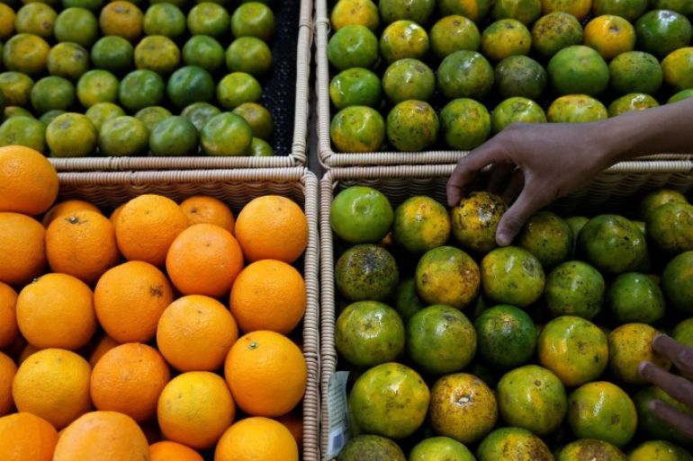 An employee puts an orange on a fruit rack at a Foodmart Fresh supermarket in Jakarta, Indonesia June 8, 2016. REUTERS/Beawiharta